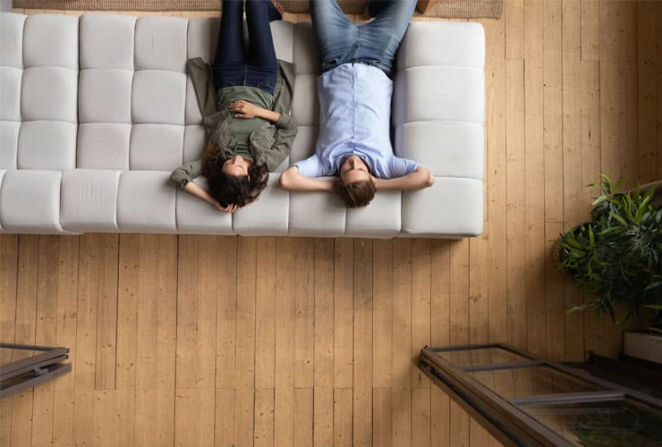 Bird's eye view of a couple lying back on a sofa in a rented flat.
