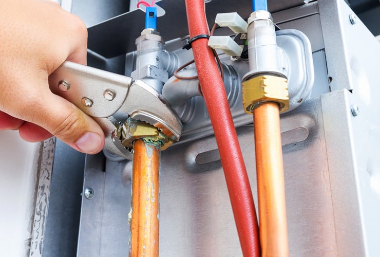 Plumber Repair Gas Boiler Close up of a plumbers hand repairing a gas boiler.