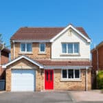 An English detached house with a red door.