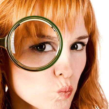 A woman looking through a magnifying glass.