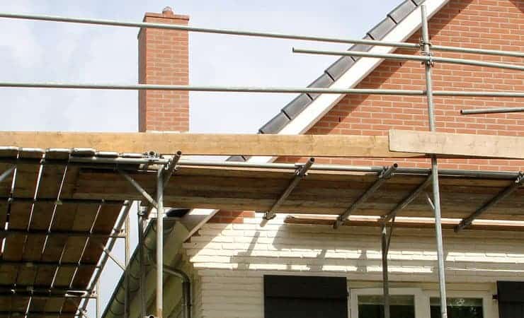 A photo of the outside of a house being reonvated. Image shows scaffolding against a suburban property.