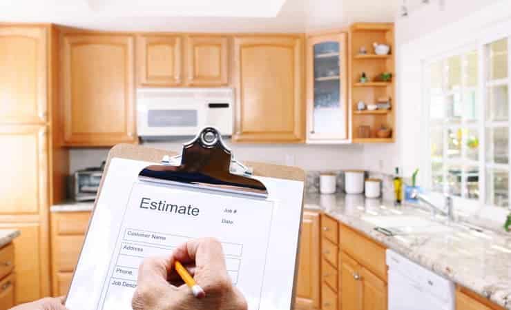 A photograph showing a closeup of a contractor's clipboard with an estimate for a kitchen remodelling project on it.