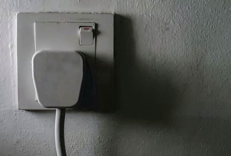 A close up black and white image of a UK plug socket.