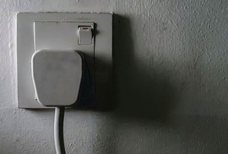 A close up black and white image of a UK plug socket.