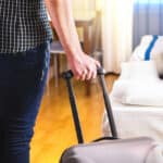 A traveller pulling a suitcase arrives at a serviced apartment.