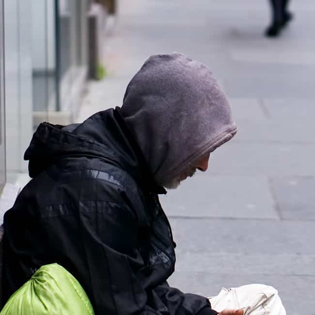 An unidentified homeless man begging on city street in Glasgow, Scotland.