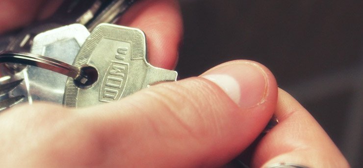 A close up of a hand holding a house key.