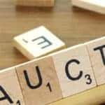 The word 'auction' written with Scrabble pieces.