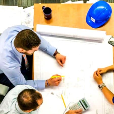 A group of business men sit around a table, planning a project.