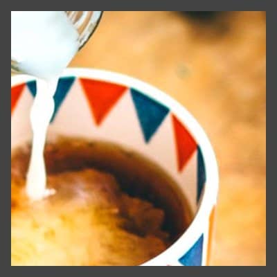 Milk being poured into a cup of coffee.