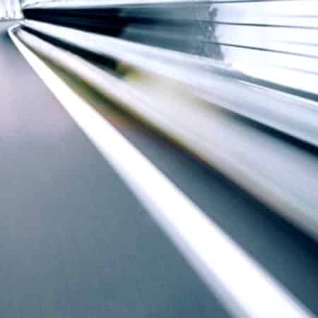 A blurred photograph of the side of a road, taken at speed.