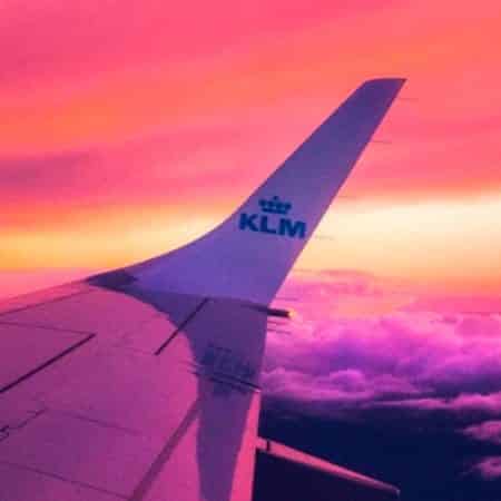 Photograph of the wing of a plane, against a sunset.