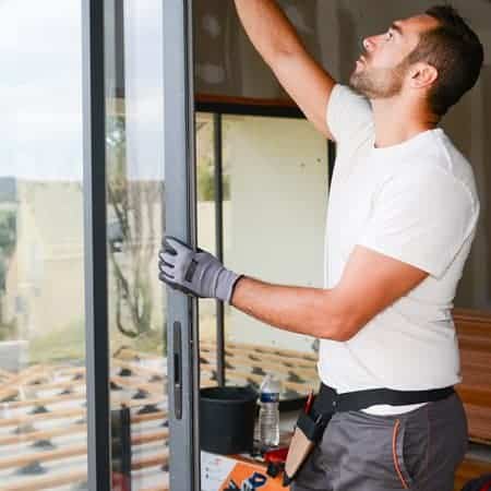 A man installing a bay window in a new-build house.