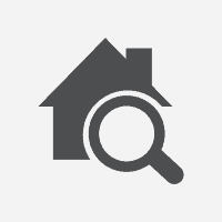 An icon showing a magnifying glass over the top of an image of a house.