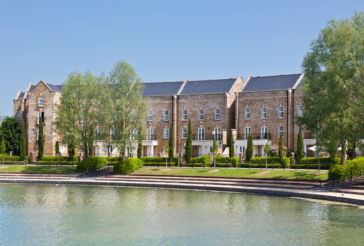 Modern urban housing by a pond on a summer day. Photograph taken in Milton Keynes.
