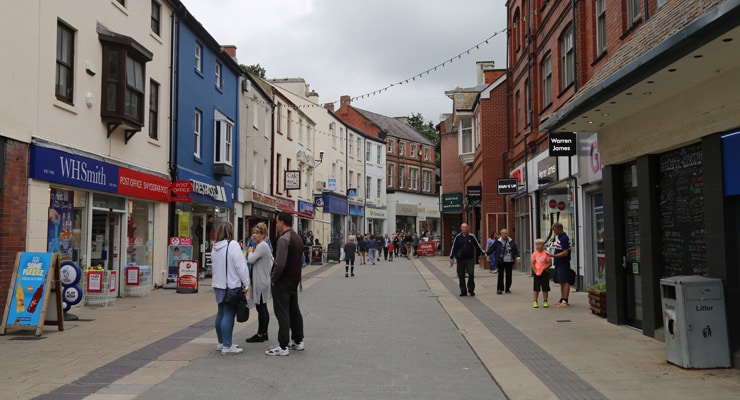 A pedestrianised high street in Bangor with shoppers and shops