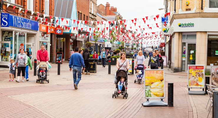 A busy shopping street decorated with bunting. Photo taken at the White Rose Centre, High St, Rhyl