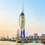 A photograph of the iconic Emirates Spinaker Tower in Portsmouth, taken at sunset.