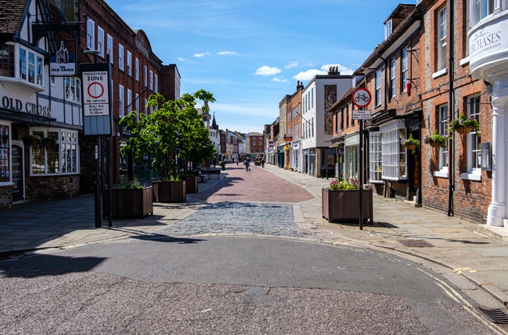 A mostly empty shopping street in the centre of Chichester on a summer day.