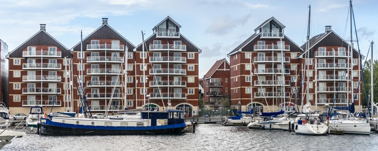 Blocks of flats on the Ipswich Waterfront, where house boats sit in the foreground.