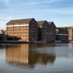 Old warehouses reflected in the water at Gloucester Quays, Gloucester, UK.