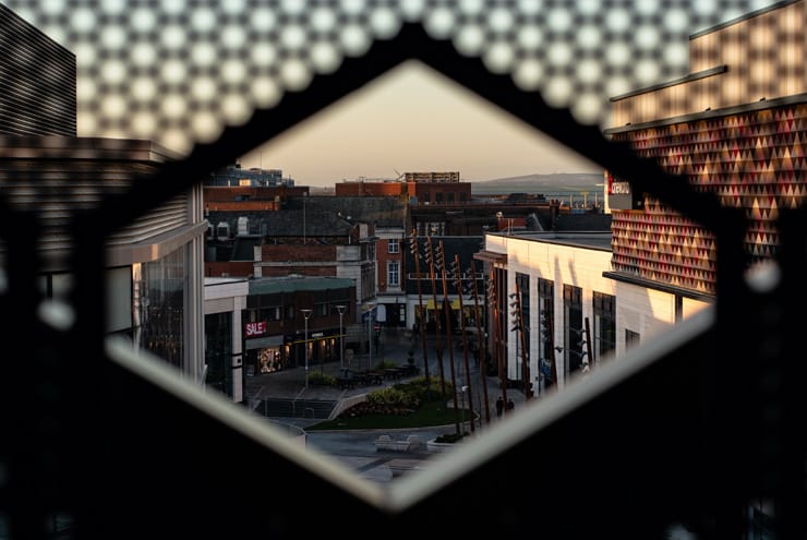 A shot of new developments in Warrington Town Centre. Photograph taken 'artistically' through a gap in a metal fence.