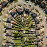 A bird's eye aerial view of a U-shaped street and suburban housing in Ipswich, UK.
