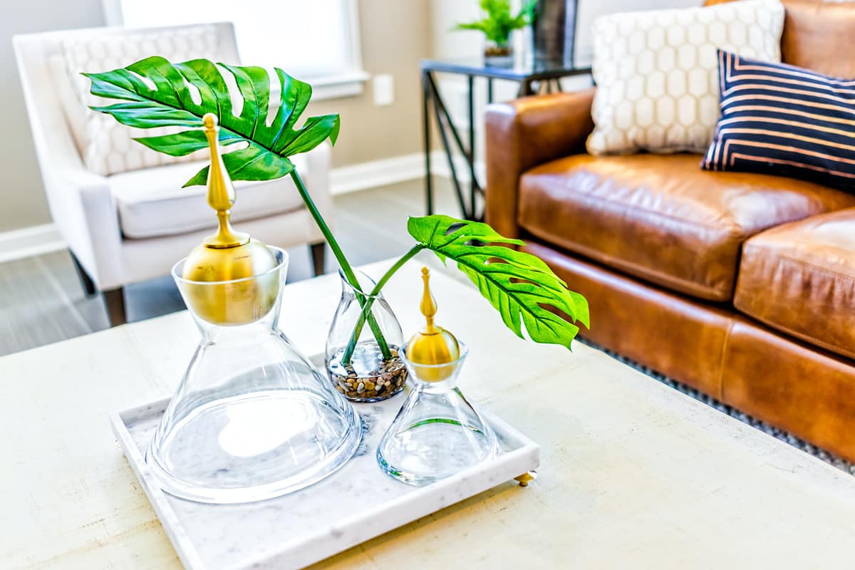 A closeup of serving tray stand with empty glasses and a plant in a home staging example.