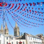 Bunting hangs from a flagpole in summer. Photograph taken in the centre of Truro in Cornwall.