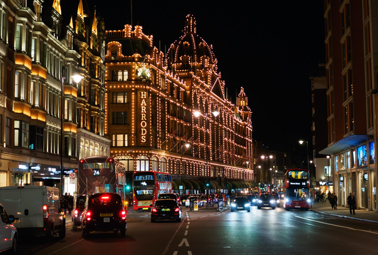 View of the Harrods Department Store on Brompton Road in Knightsbridge, London at night.