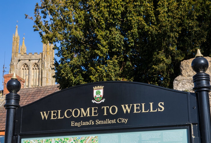 Sign says, "Welcome to Wells, England's Smallest City".