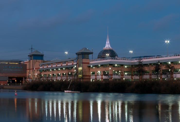 The Lakeside Shopping Centre in Thurrock is reflected in the water at twighlight.