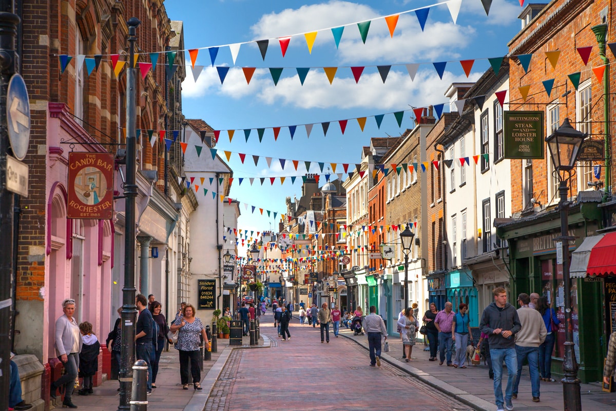 Shoppers wander the high street in Rochester with bunting overhead.