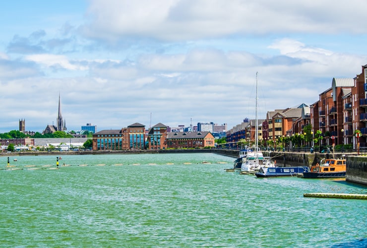 The docklands in Preston. A stretch of water on a sunny day with residential housing in the background.