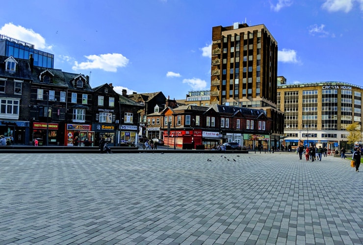 St George's square in Luton on a sunny day with tourists, shoppers and people walking.