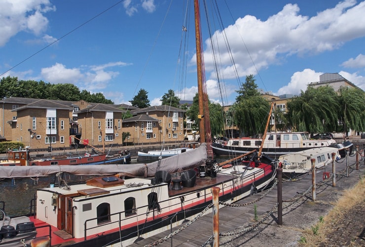 Canal boats with residential houses in the background. Photograph taken near Deptford.