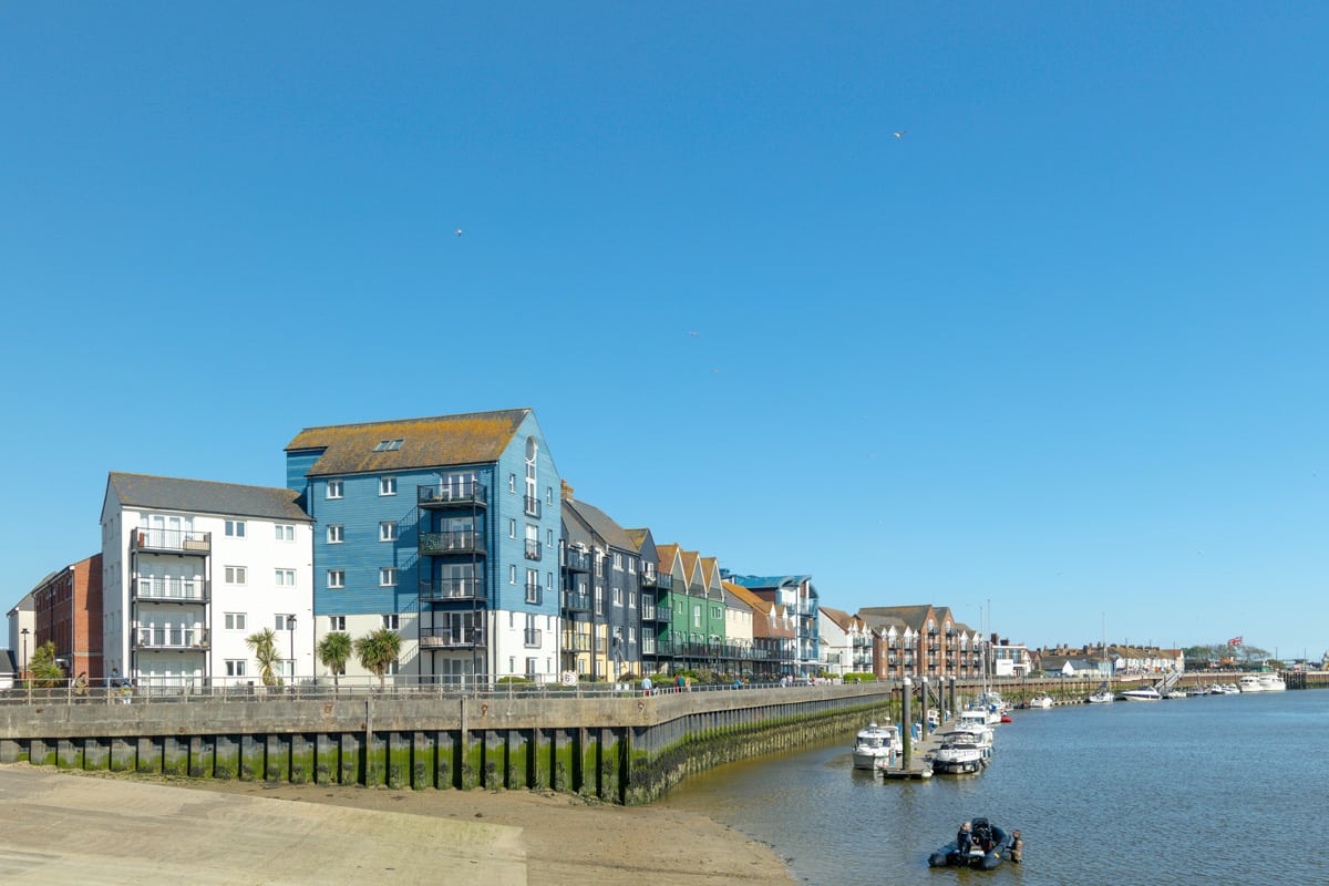 Residential blocks of flats sit alongside a harbour in Littlehamptopn Bay, Littlehampton, West Sussex.