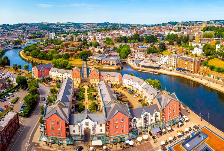 An aerial view of Exeter city along the river on a bright-blue day.