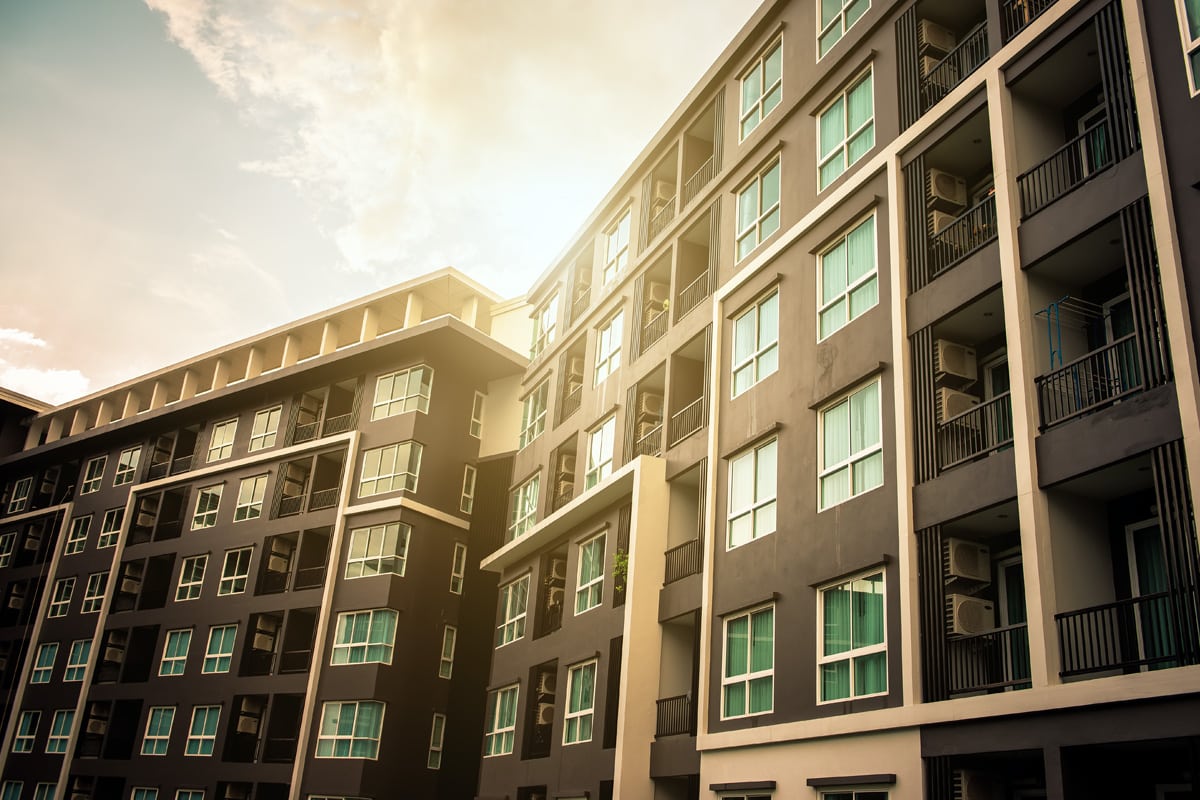 Looking up at a new apartment building as the sun is reflected off the windows.