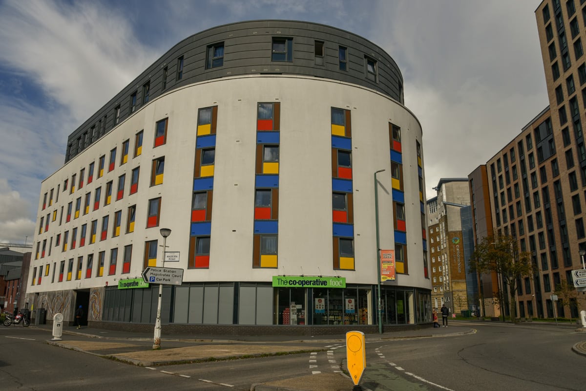 Colorful student accommodation building with a Co-operative food store in the ground floor.