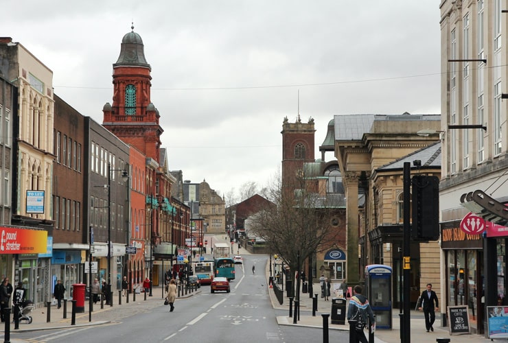 People visit a shopping street in Bolton, UK.