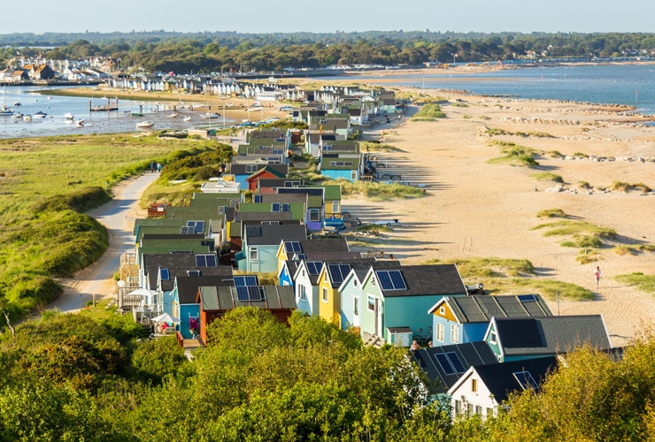 Colourful beach huts on the sand at Hengistbury Head in Bournemouth.