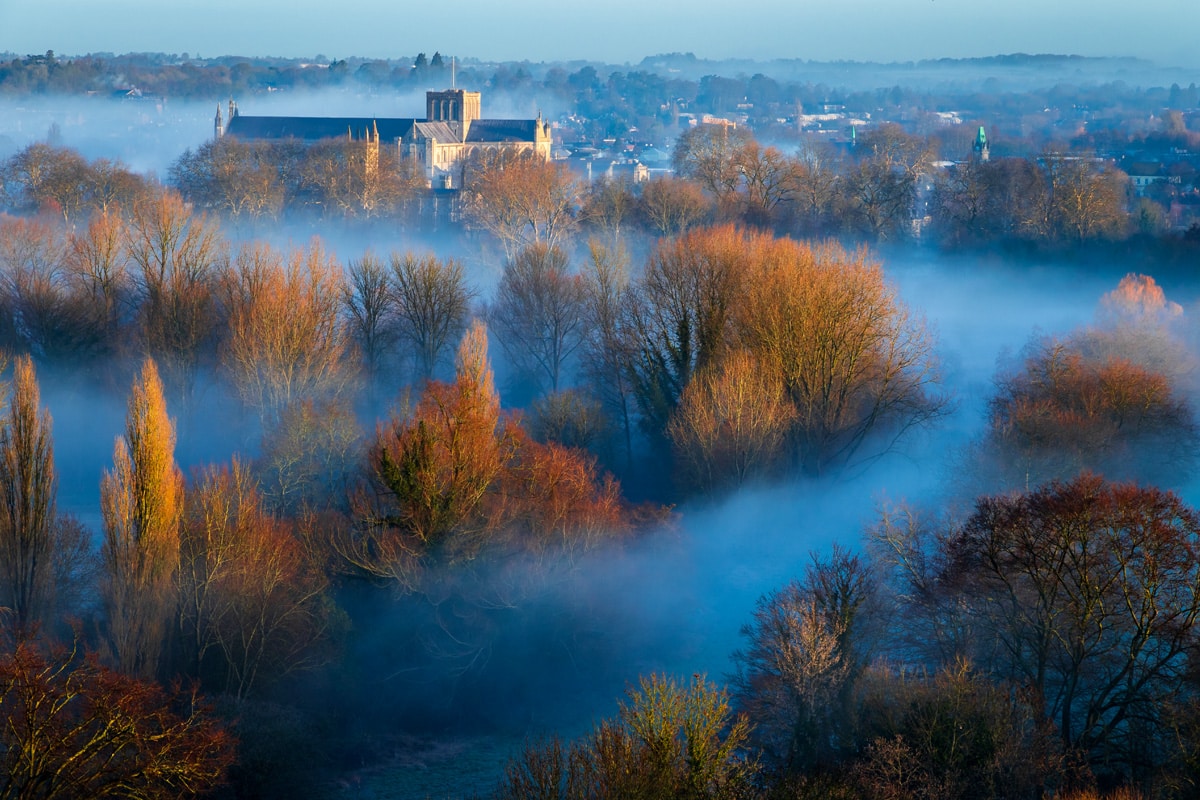 Winchester Cathedral in Hampshire, in the south downs, rises over mist in the early morning.