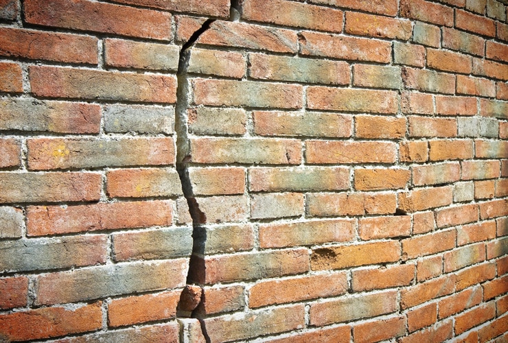 A deep crack in a brick wall.