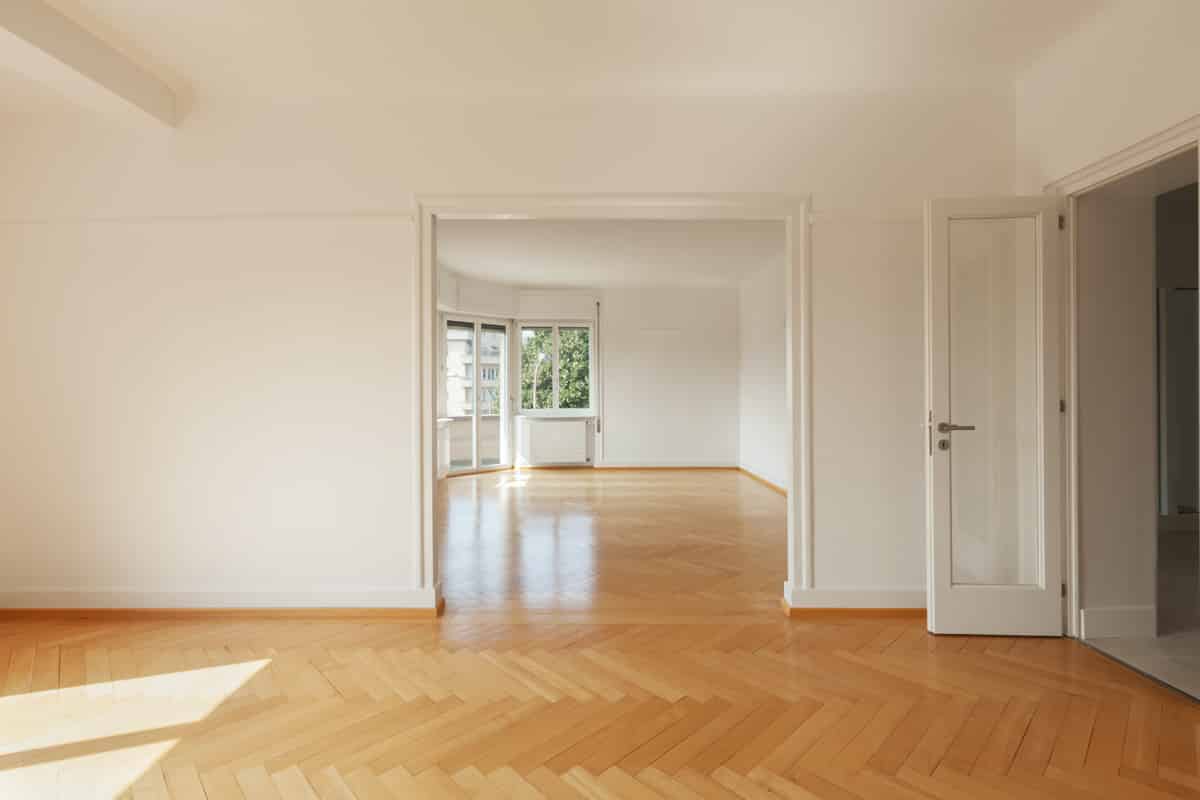 The interior of a modern apartment with wooden floors and completely empty and free of furniture.