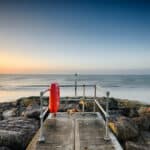 A small jetty on the beach at Sandbanks in Poole, Dorset, looking out towards Old Harry Rocks.