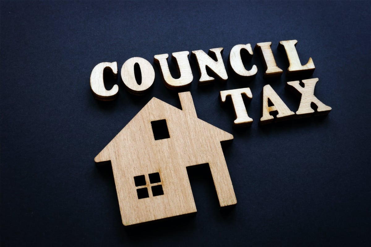 A wooden model of a house and text that reads, 'Council Tax'.