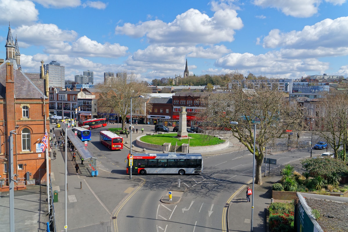 Busses go round a roundabaout. A slightly elevated view of Walsall town centre.