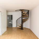 A hallway in a maisonette apartment with a spiral staircase.