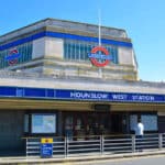 A man stands outside Hounslow West underground tube station.